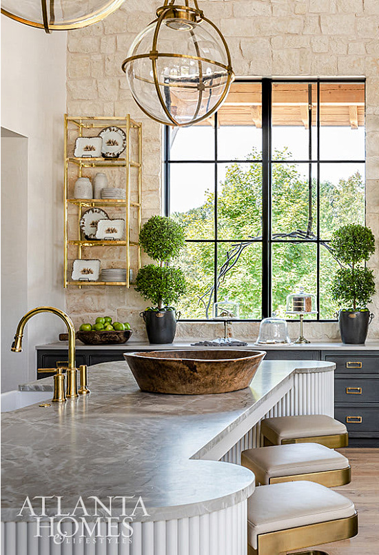gold-pendants-counter-stools-stone-walls-kitchen